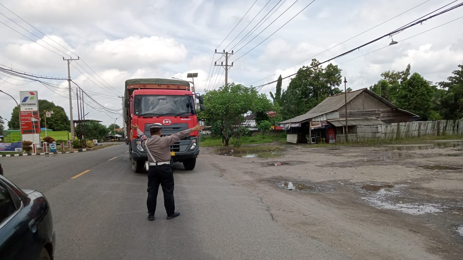 pengaturan arus lalulintas dan pengantongan mobil bermuatan barang dengan sumbu tiga atau lebih